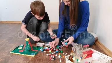 妈妈带儿子搭建分子模型的彩色塑料搭建套装..